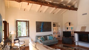 Uma sala de estar ampla com sofá, televisão e lareira.