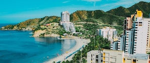 A coastal area with a beach, buildings, and hills. - Spectacular luxury apartment, partial ocean view (Gaira)