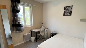 A bedroom with a bed, a desk, a chair, a radiator, and a window with curtains. - SAINT-JEANNET, Village in the Préalpes d'Azur, near NICE, SAINT-PAUL-DE-VENCE (Saint-Jeannet)