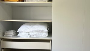 A closet with shelves and drawers, containing folded towels and a white pillow. - SAINT-JEANNET, Village in the Préalpes d'Azur, near NICE, SAINT-PAUL-DE-VENCE (Saint-Jeannet)