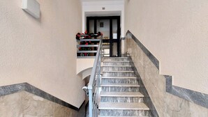 A marble staircase with a metal railing leading to a door. - Casa Lenilli - Beautiful apartment in Testaccio (Roma)