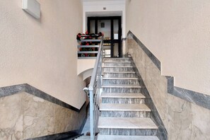 A marble staircase with a metal railing leading to a door. - Casa Lenilli - Beautiful apartment in Testaccio (Roma)