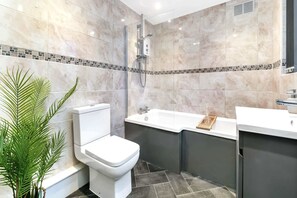 Ein modernes Badezimmer mit Toilette, Dusche und Waschbecken.