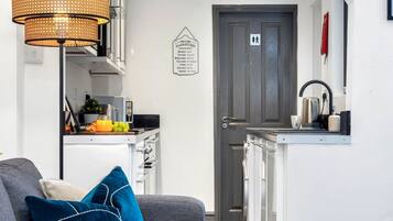 A compact kitchen with a dining area, a coffee machine, and a fruit bowl.