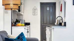 A compact kitchen with a dining area, a coffee machine, and a fruit bowl.