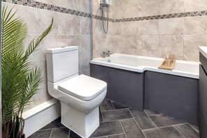 A bathroom with a toilet, bathtub, and shower. - Chorlton House | Free Parking | 2BR Stoke-on-Trent (Stoke-on-Trent)