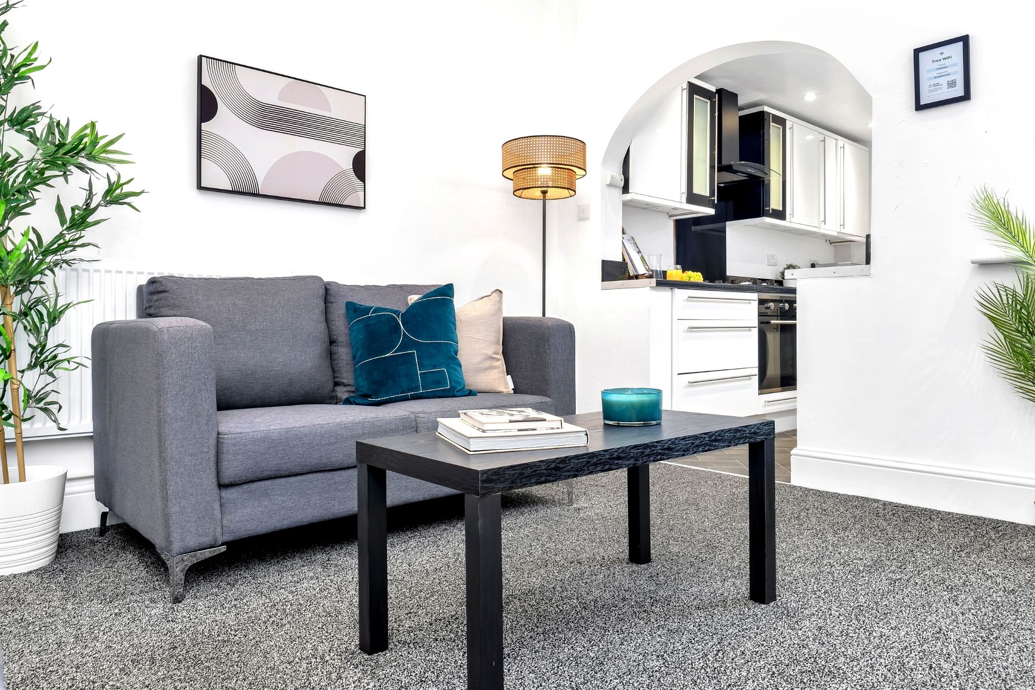 A modern living room with a grey sofa, a coffee table, and a floor lamp.
