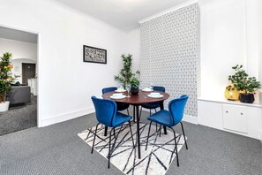 A conference room with a round table, blue chairs, and a patterned wall.