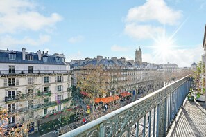 A cityscape with historic buildings, a prominent tower, and a busy street below a bridge. - Beautiful Apartment - Ac-1br- 3P - Les Halles (Paris)