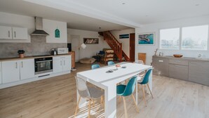 Una cocina moderna con armarios blancos, una mesa de comedor de madera y sillas azules.