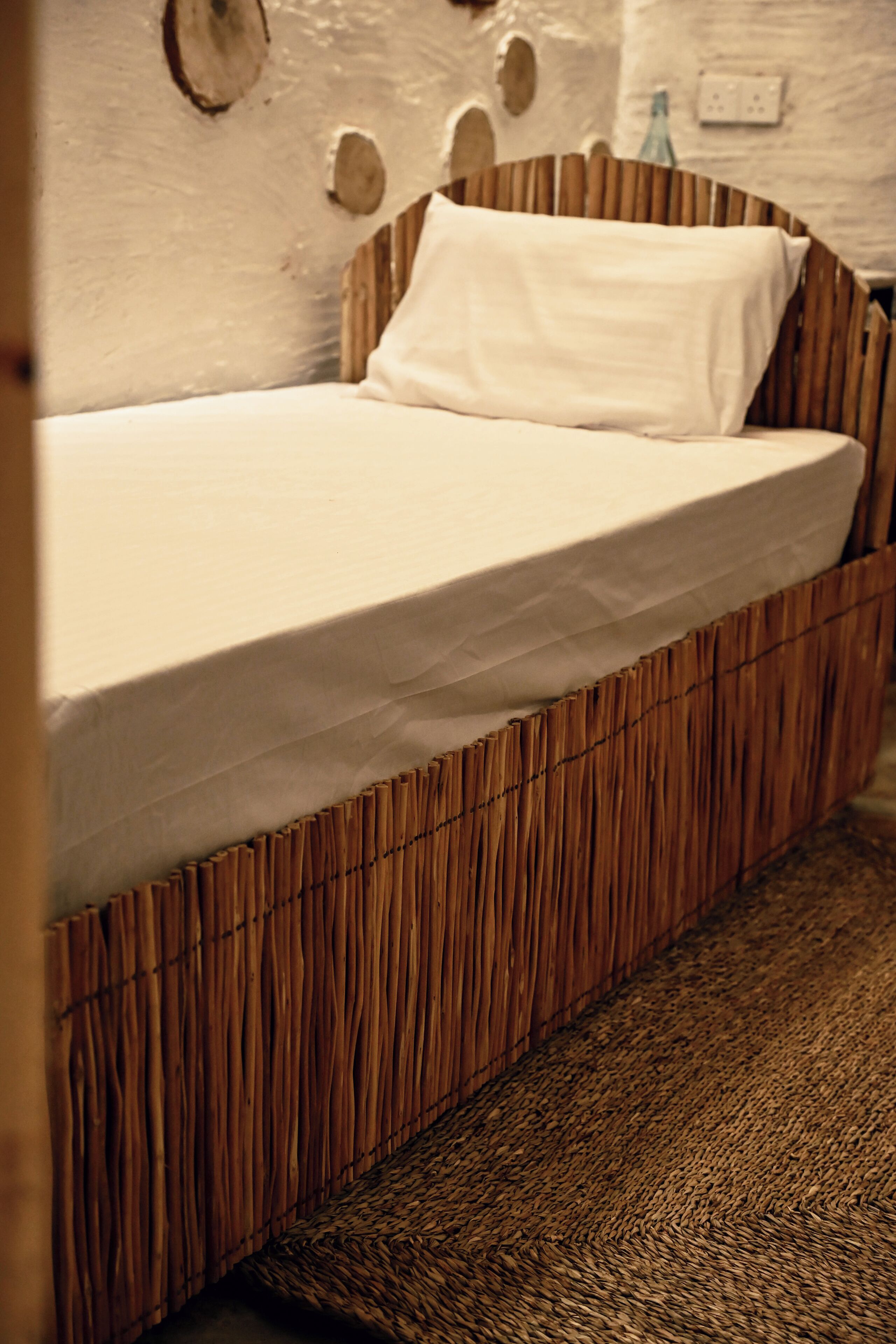 A bed with a wooden frame and a white mattress.