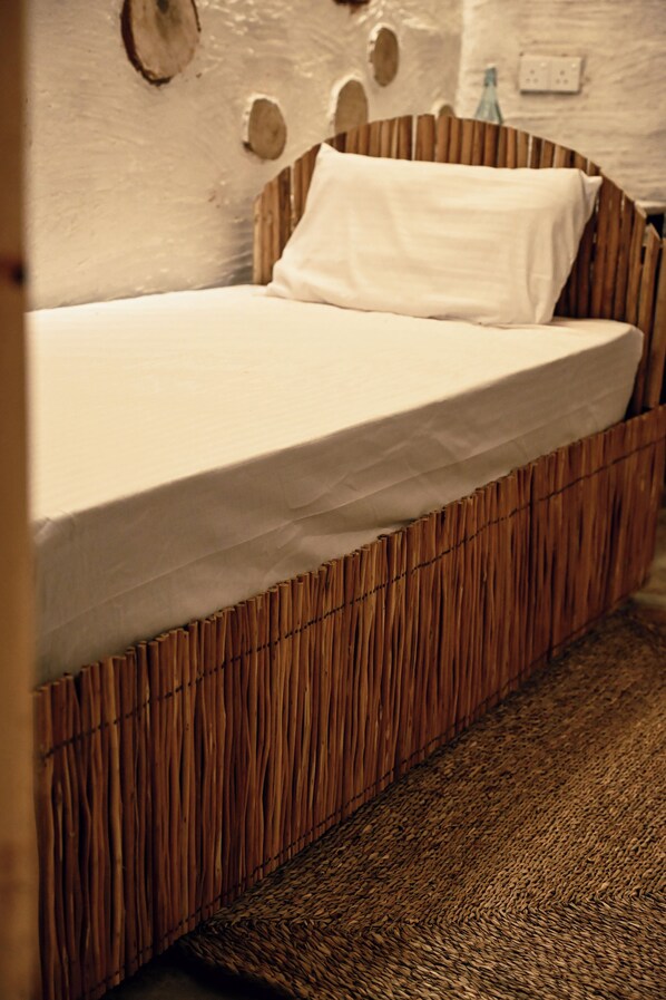 A bed with a wooden frame and a white mattress. - Gal Oya Heritage Retreat (Galgamuwa)
