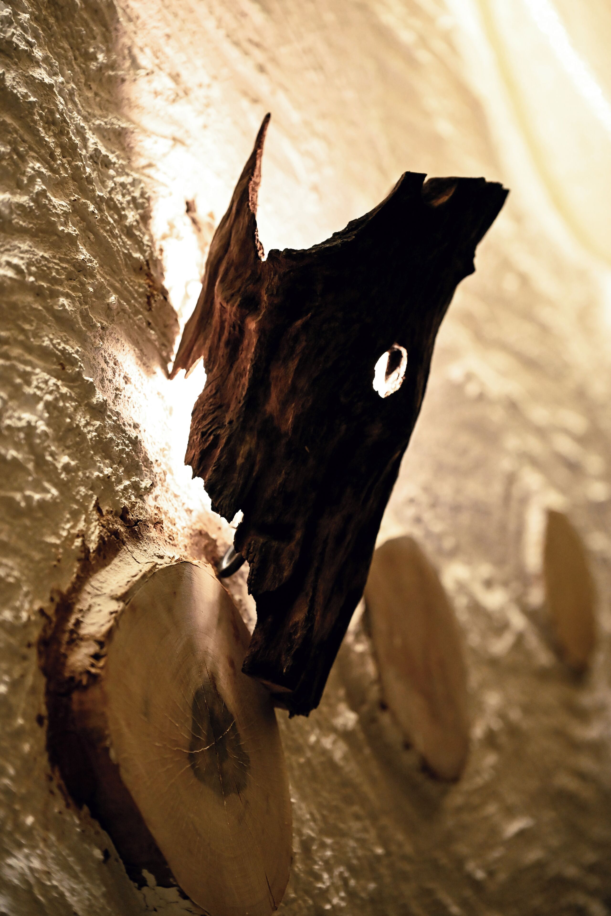 A close-up of a wooden surface with a hole, possibly a part of a wall or furniture.