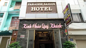 Paradise Saigon -hotellin ulkonäkö: näkyvissä vietnaminkielinen kyltti ja neonvalomainos.