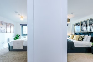 A bedroom with a bed, a window, and a wall-mounted light fixture. - 2BDR | Free Parking | Stylish Liverpool Apartment (Liverpool)