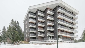 A multi-story building with balconies, surrounded by snow. - Cozy Mountain Base Near Bachat Bouloud (Chamrousse)