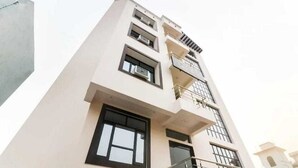Un edificio de varios pisos con un diseño arquitectónico moderno, que cuenta con amplios ventanales y balcones.