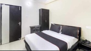 Un dormitorio con cama, armario y escritorio.