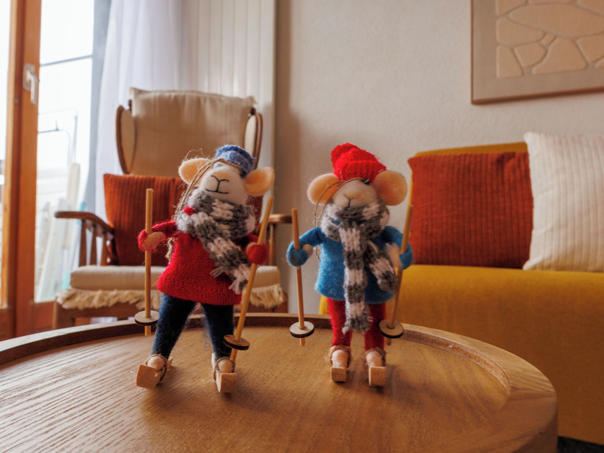 Two plush toys on a wooden table in a room with a sofa and a chair.