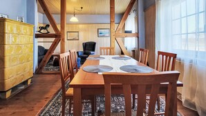 A dining area with a wooden table and chairs, a yellow cabinet, and a chandelier. - Mit großem Garten by Interhome (Hohenbucko)