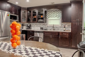 Una cocina moderna con armarios de madera oscura, electrodomésticos de acero inoxidable y mantel a cuadros.
