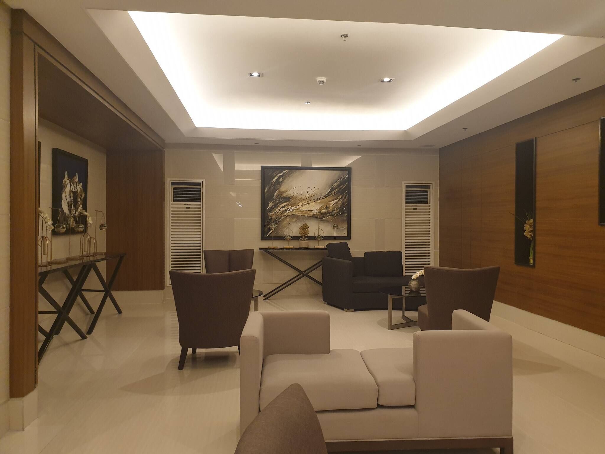 A modern living room with a ceiling light, a painting, and a sofa.