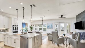 A modern kitchen with a central island, stainless steel appliances, and pendant lighting. - SunnySide: Private beach steps away, FREE Golf Cart, Heated pool, Luxury home (Destin)