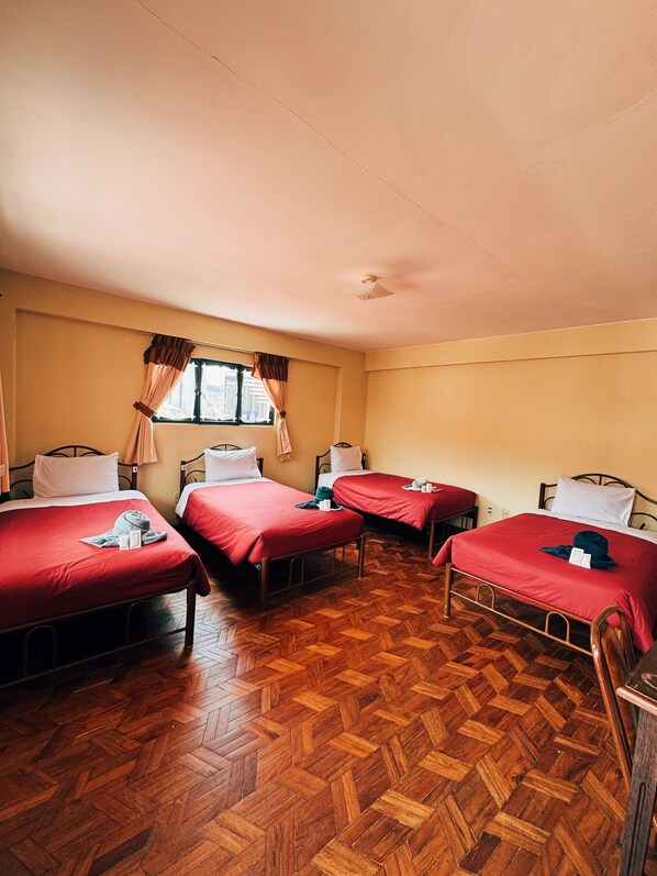 A room with four beds, each with red bedding, wooden flooring, and a window with curtains. - YORK HOUSE (La Paz)