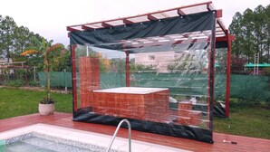 Un área de jacuzzi techada con cubierta de madera y estructura de metal.