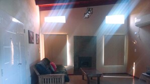Un salón espacioso con chimenea, un banco de madera y un sofá.