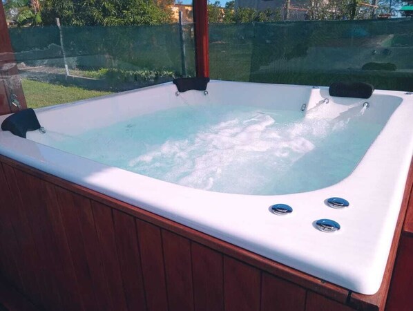 A hot tub with a wooden exterior and two control buttons on the side.