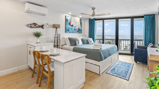Ein modernes Schlafzimmer mit Bett, Schreibtisch und Balkon mit Blick.