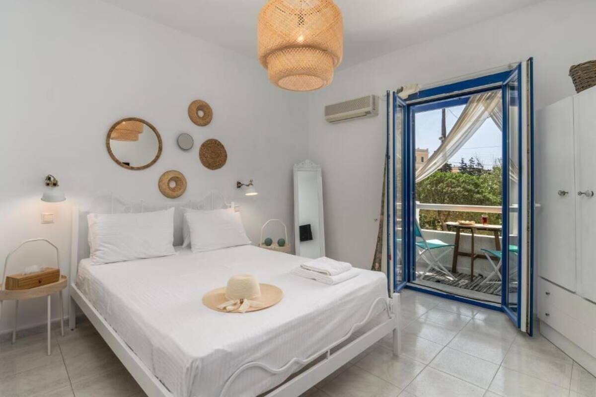 Une chambre à coucher avec un lit, une table de chevet et une vue sur une terrasse extérieure.