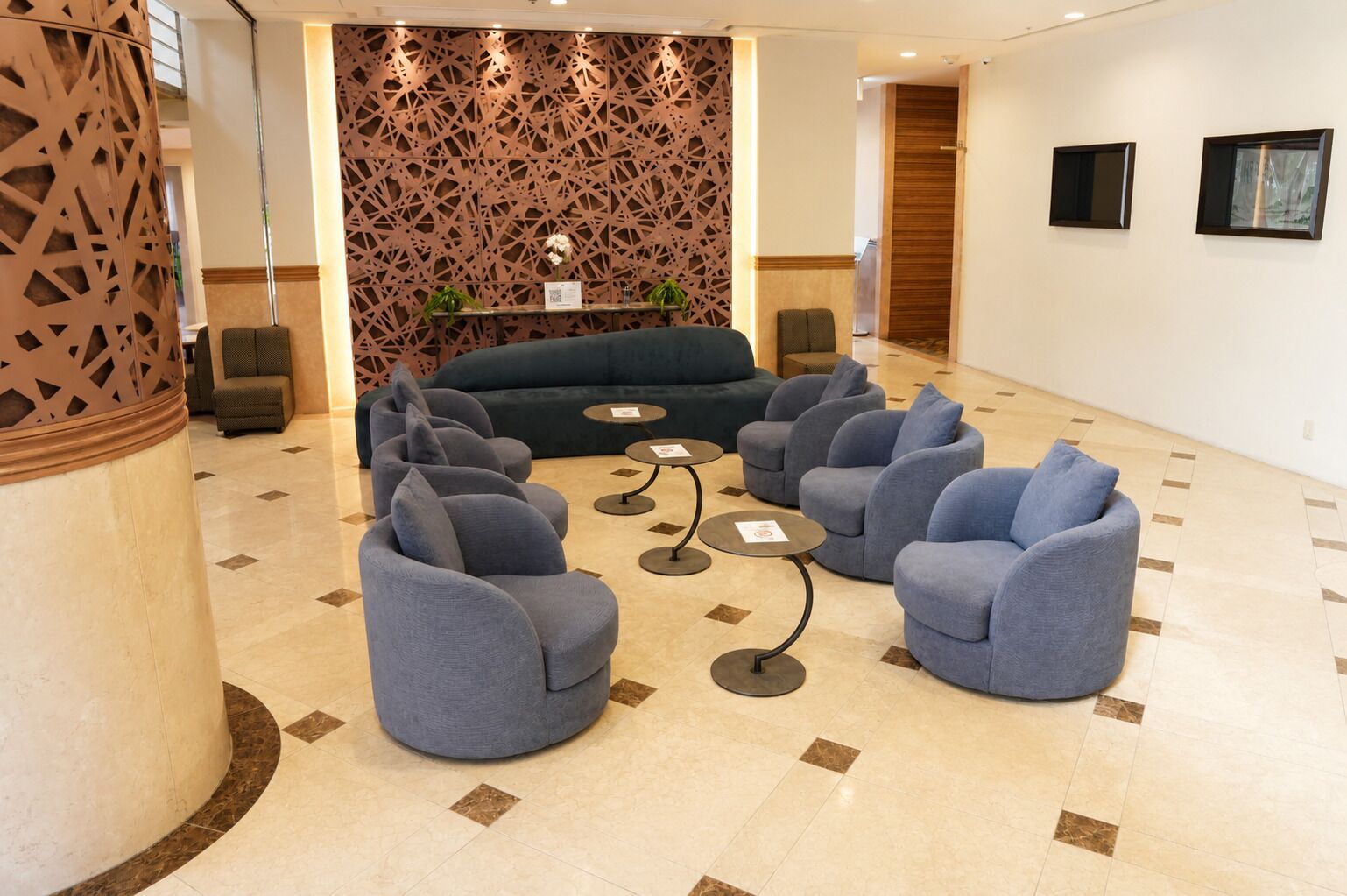 Un hall con sofá, zona de estar y un muro decorativo.