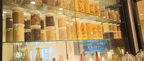 A display of glass jars containing various nuts and grains, and several glass vases on shelves.