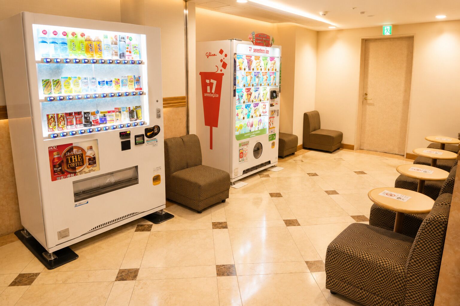 A hotel lobby with vending machines, seating areas, and a door.