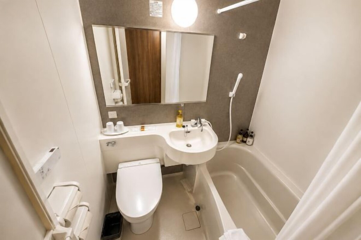 Ein kleines Badezimmer mit Toilette, Waschbecken und Badewanne.