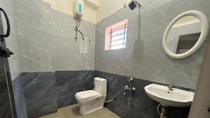 A bathroom with a toilet, sink, and mirror. - S L N COMFORT (Bengaluru)