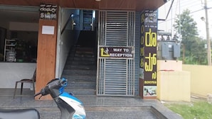 A building entrance with a sign indicating a way to the reception and rooms. - S L N COMFORT (Bengaluru)