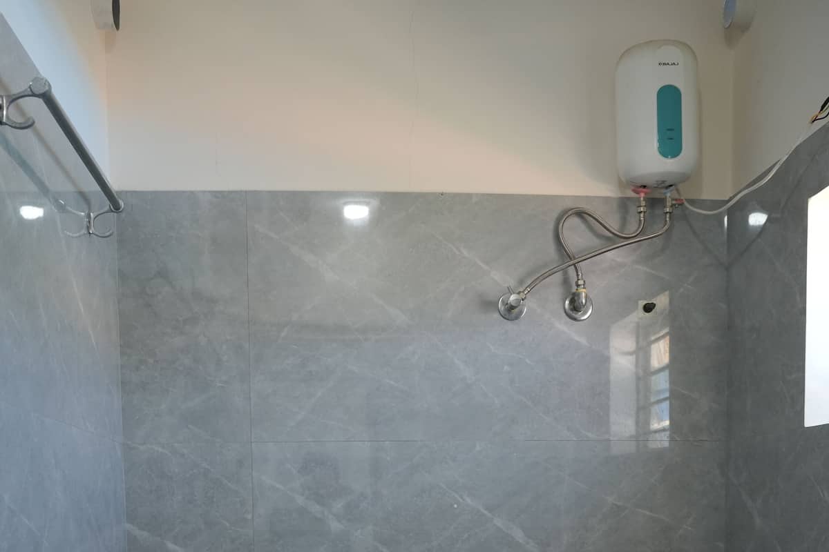 Ein Badezimmer mit einem weißen Waschbecken, einer Toilette und einem an der Wand befestigten Handtrockner.