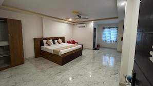 A bedroom with a bed, a wardrobe, a ceiling fan, and a door. - S L N COMFORT (Bengaluru)