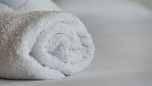 A rolled white towel on a white surface. - La casa di Gio'- Apartamento Rustico Legno (CALTANISSETTA)
