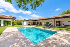 A modern house with a swimming pool, covered patio, and a well-maintained lawn. - Hacienda style home 4 bedrooms in Las Golondrinas, Hacienda Pinilla (Pinilla)
