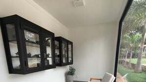 A modern interior with a seating area, a large window, and built-in cabinets. - pousada ibiza (Pirenopolis)