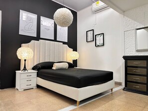 A modern bedroom with a large bed, two bedside lamps, a dresser, and framed artwork on the walls. - Group Stay 21 Guests, Wifi 900 Mb (Medellín)