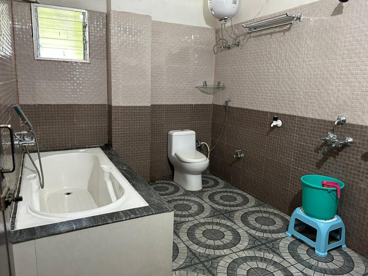 Et badeværelse med badekar, toilet og bruser.