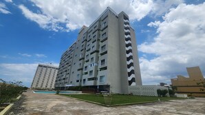 A high-rise residential building with multiple balconies, a swimming pool, and a well-maintained lawn. - Ocean View 1-bedroom apartment with Pool View in heart of Kingston (Kingston)