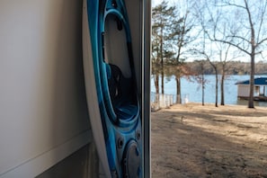 Un kayak à l’intérieur d’un véhicule, une vue sur un lac avec des arbres et un quai.