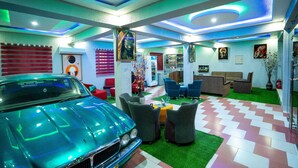 A modern interior with a classic car, green artificial grass, and contemporary furniture. - Eastern Plus Hotel  (Somanya)