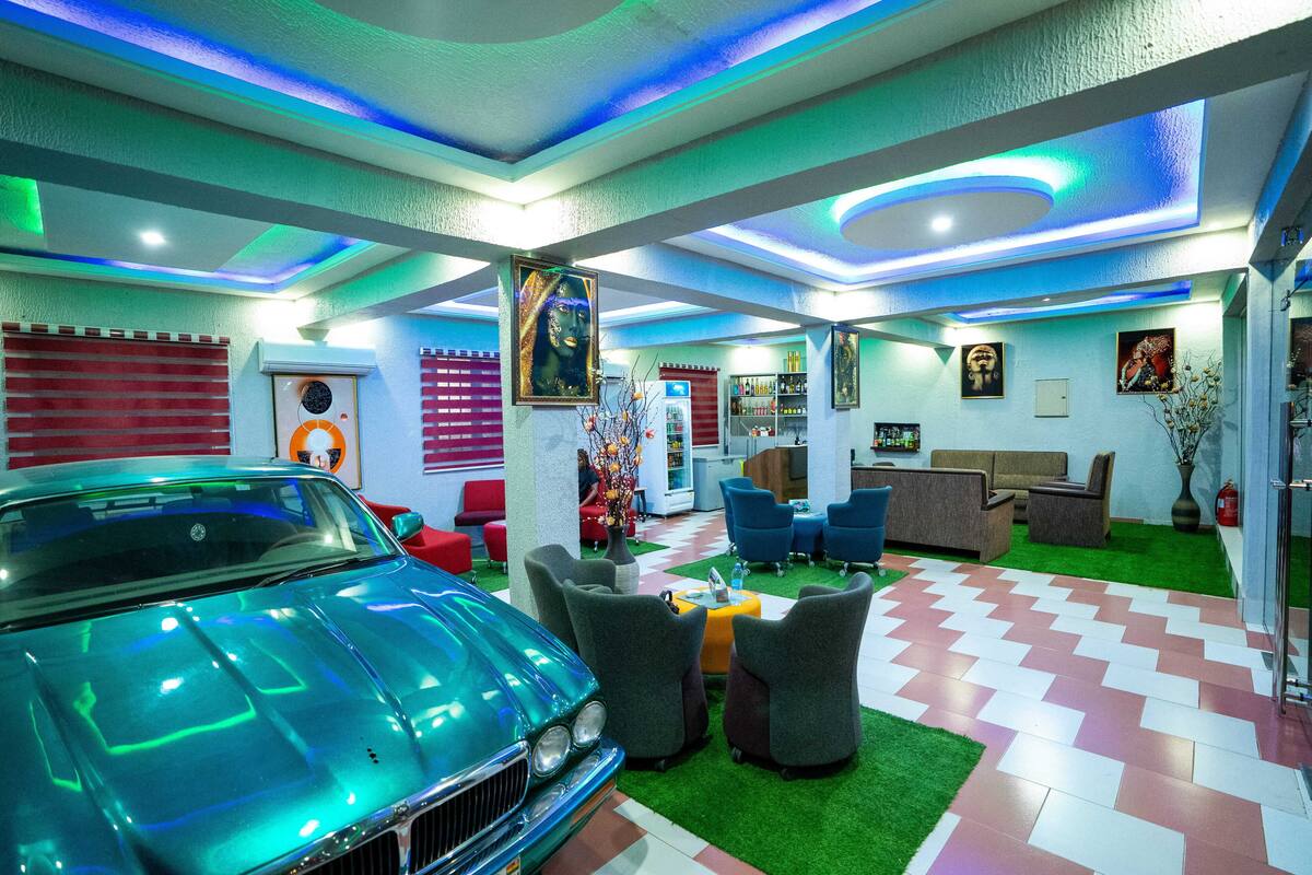 A modern interior with a classic car, green artificial grass, and contemporary furniture.